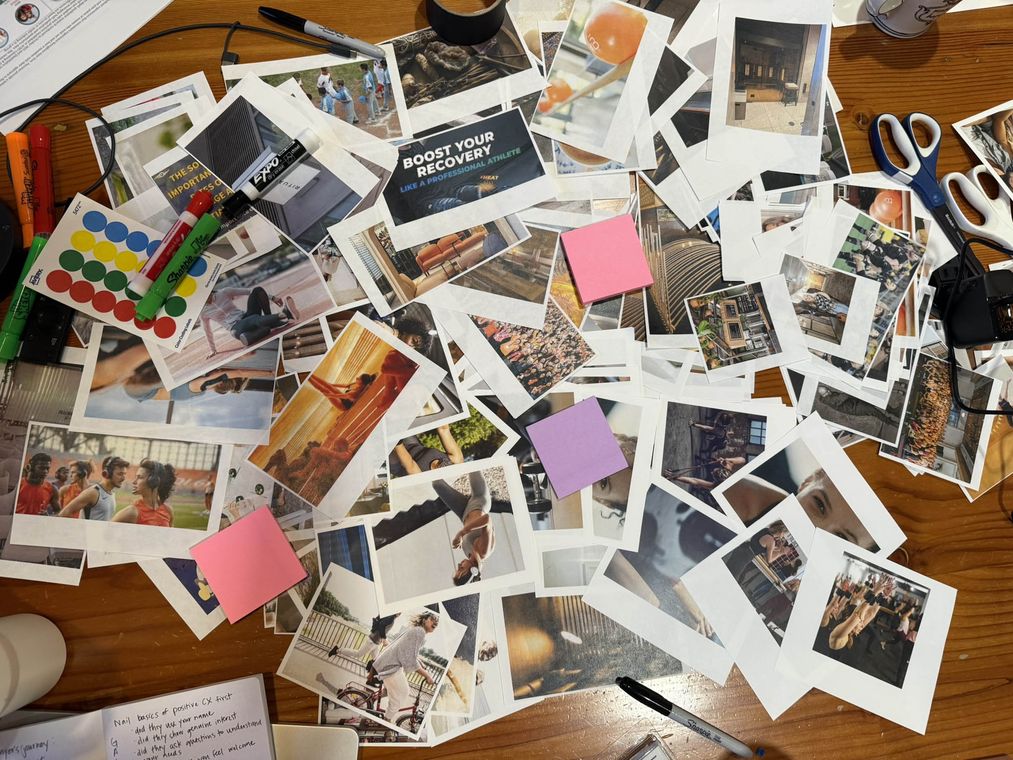 Customer research moodboard exercise: printed photographs, sticky notes and markers on a workshop table for brand and customer experience strategy